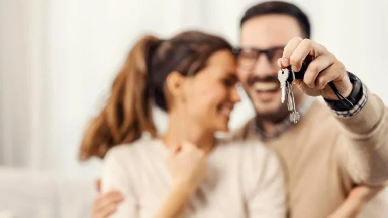 Happy couple holding house keys after bad credit mortgage approval