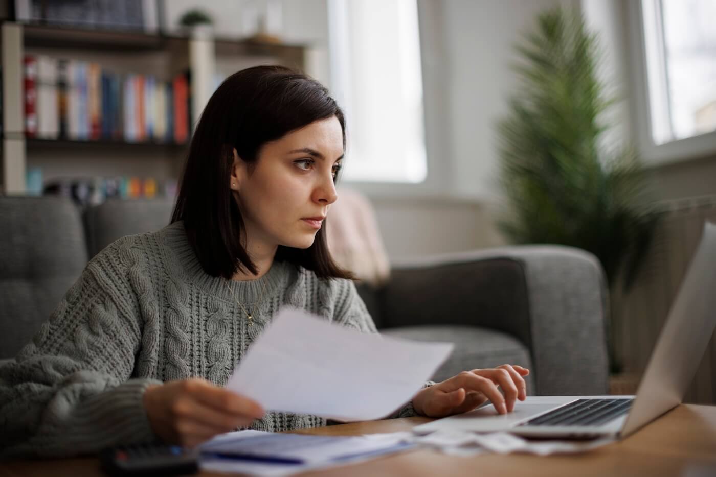 Woman carefully reviewing financial documents to find credit report errors