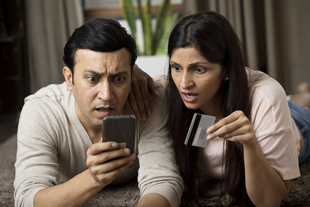 Couple looking shocked at a fraudulent credit card statement