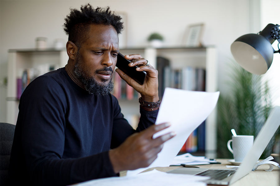 Man on the phone disputing a late payment with his lender