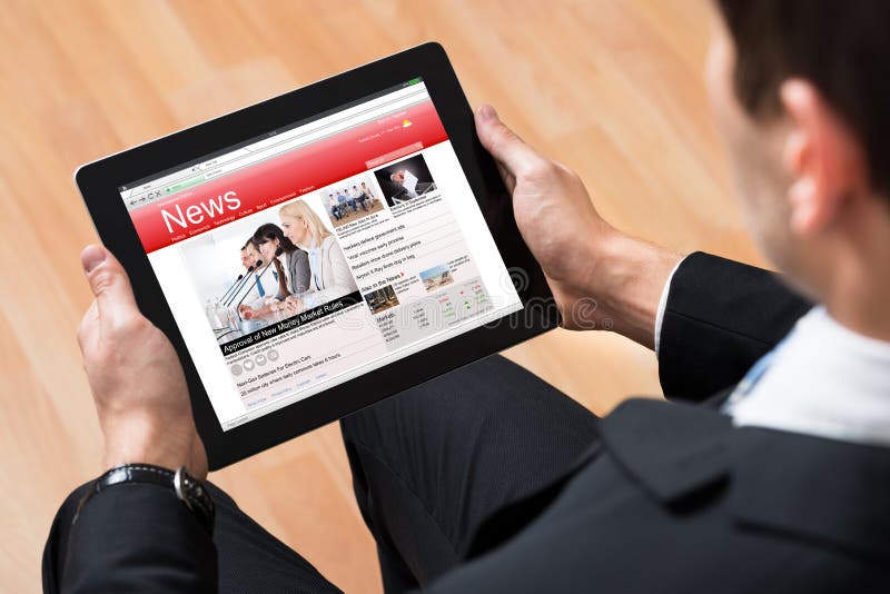 Businessman reading financial news on a tablet device